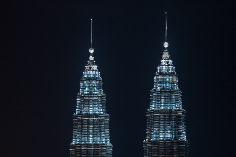The illuminated spires and ring balls of Kuala Lumpur's Petronas Twin Towers are illuminated at night.