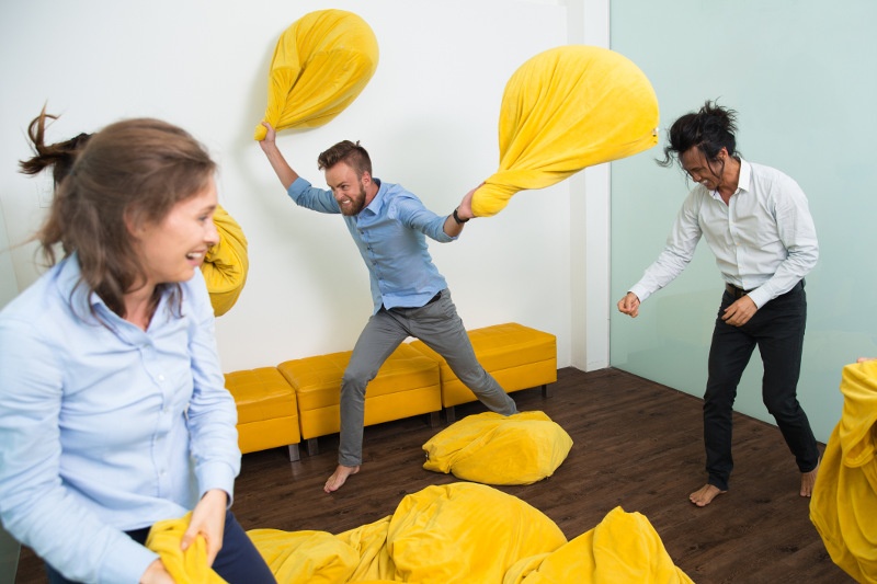 Three people engage in a beanbag fight.