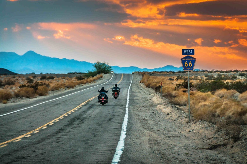 Bikers driving Route 66 at sunset