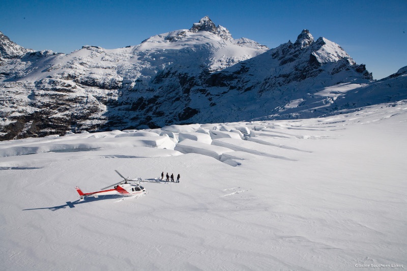 people and helicopter in snow new zealand