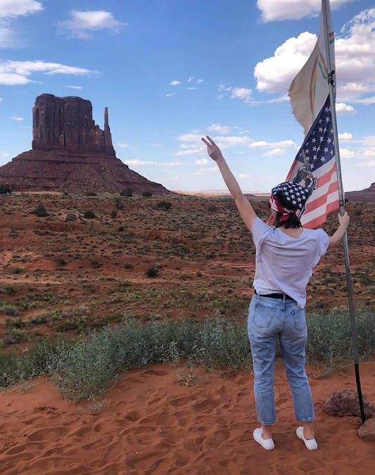 Woman holding an American flag at Monument Valley 