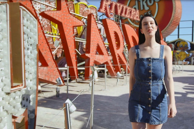 Laura walking through the Neon museum during the day with vintage Las Vegas signs in the background