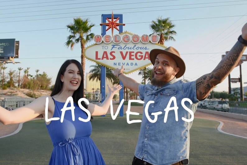 Laura and Troy standing excited in front of the Las Vegas sign 