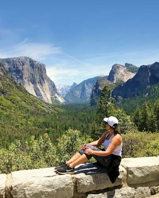 Cassie sitting and looking out at the views of El Capitan, Half Dome and the Yosemite Valley.