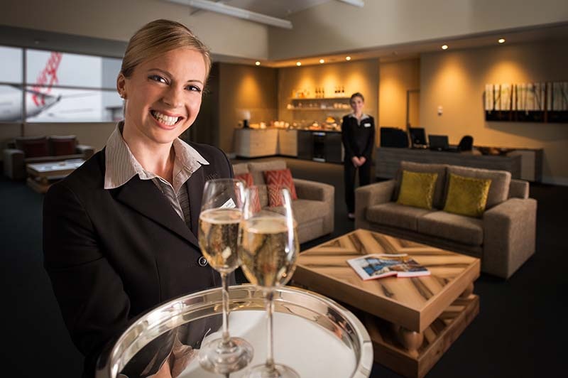 waiter serves champagne in saffire lounge at hobart airport
