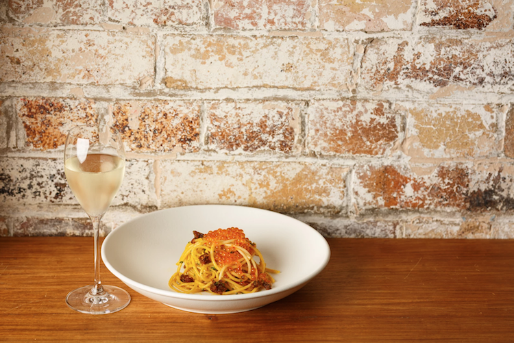 Siffredis pasta dish alongside a glass of white wine 