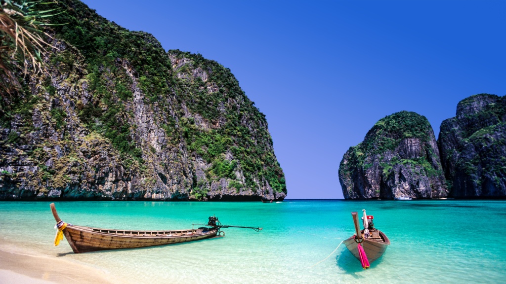 taxi boats parked on the shore of the crystal blue maya bay