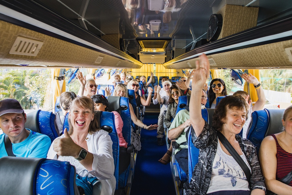 Bus full of tourist raising their hand and ready to go to their destination