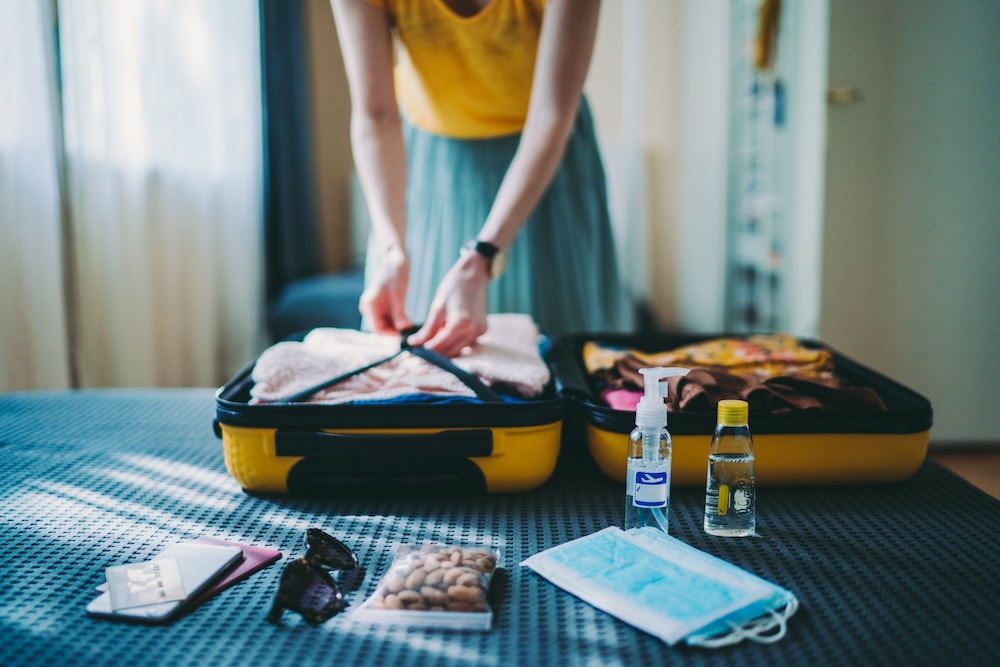 Lady fixing her clothes and stuff inside her suitcase