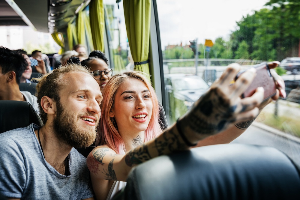Couple smiling and taking selfie while inside the bus
