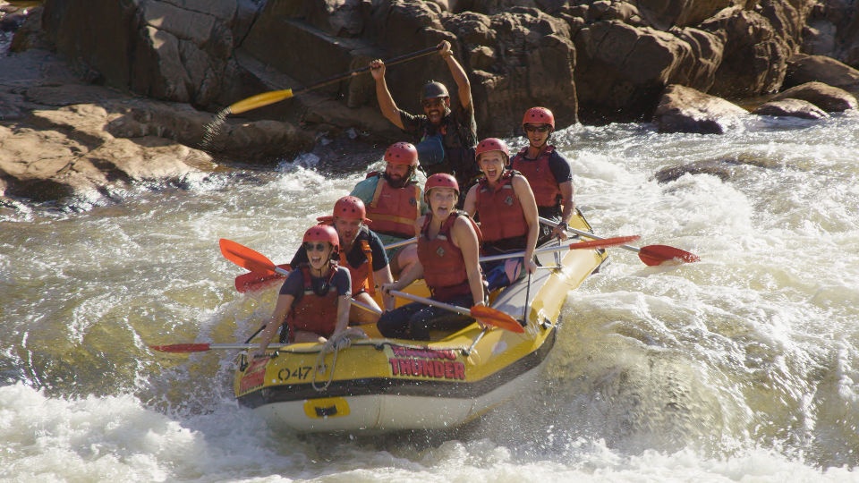 Tourists in a raft enjoying the rapids