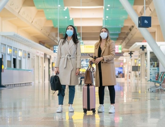 two people in airport with masks looking up 