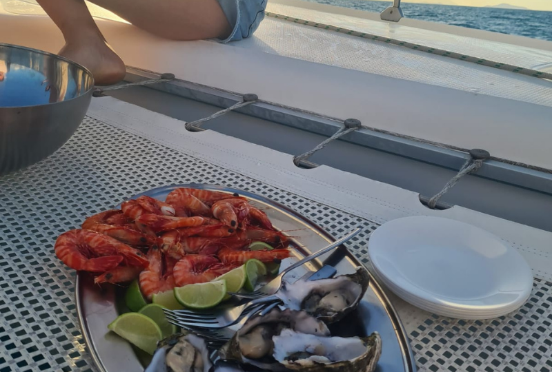 a platter of shrimp, oyster, and limes in a boat sailing around the Whitsunday Island