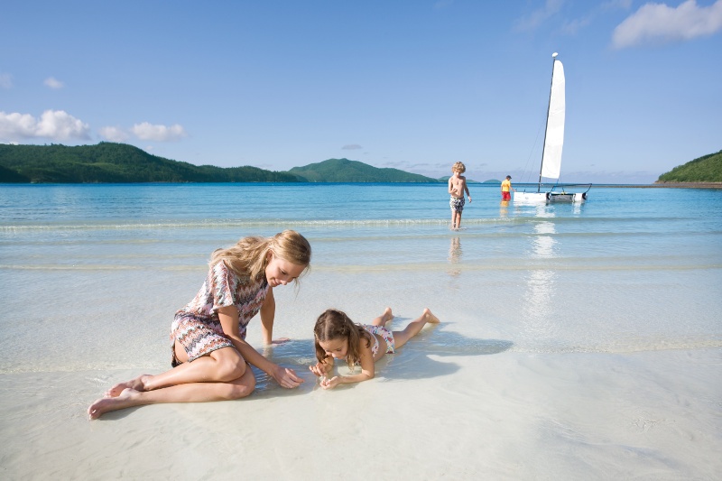 A mother and child play in the shallows of Catseye Beach on Hamilton Island.