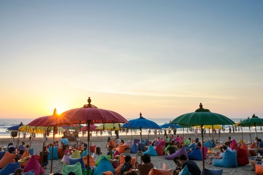 a crowd under colorful beach umbrellas  enjoying the summer at Seminyak Kuta and Legian