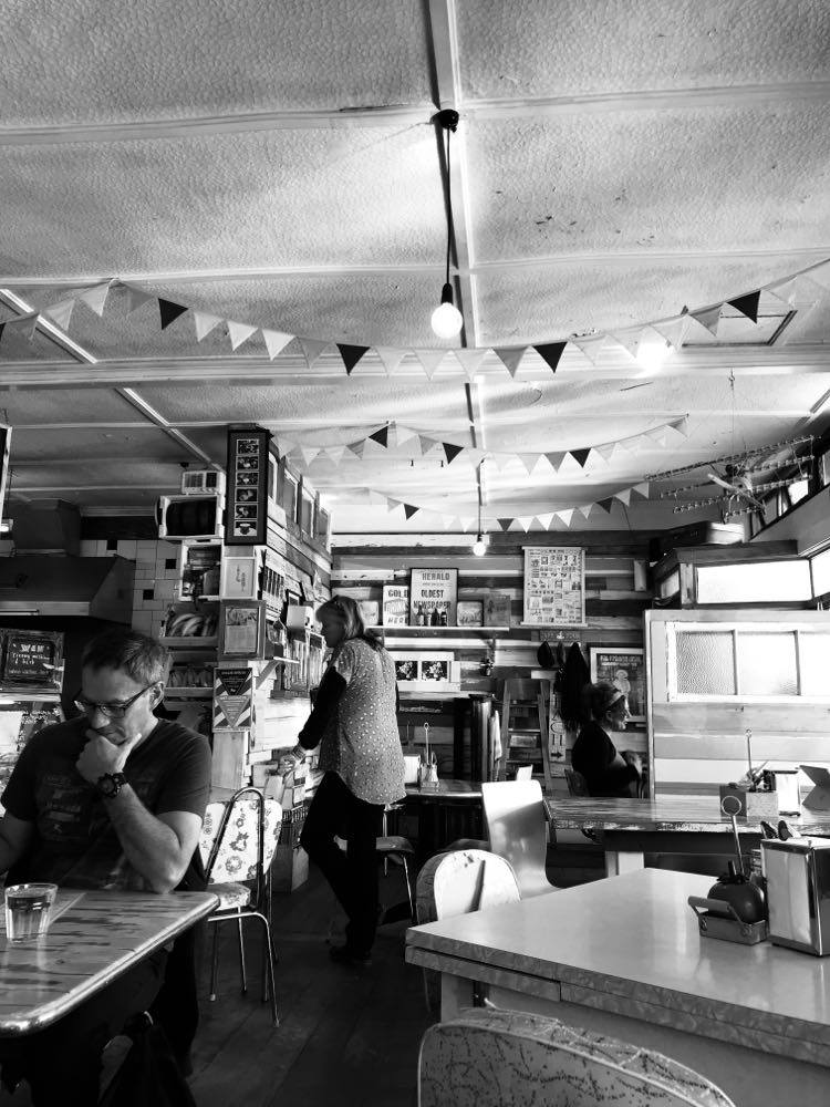 A black-and-white picture of people in a retro cafe.