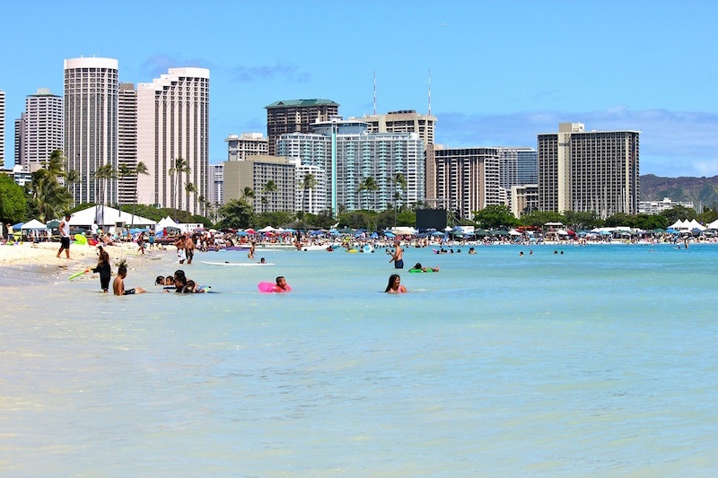 people swimming in shallow water at Waikiki Beach Hawaii