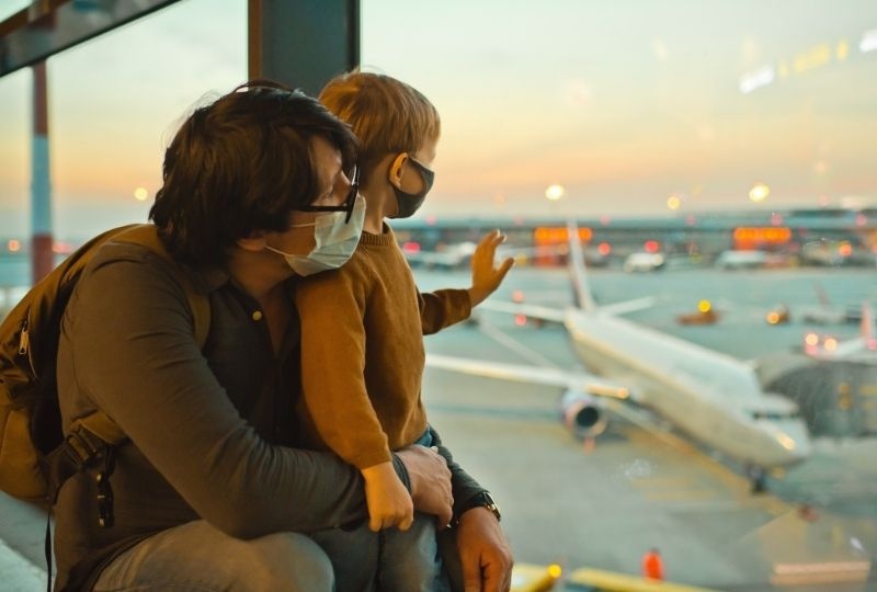 At the airport, wearing a facemask