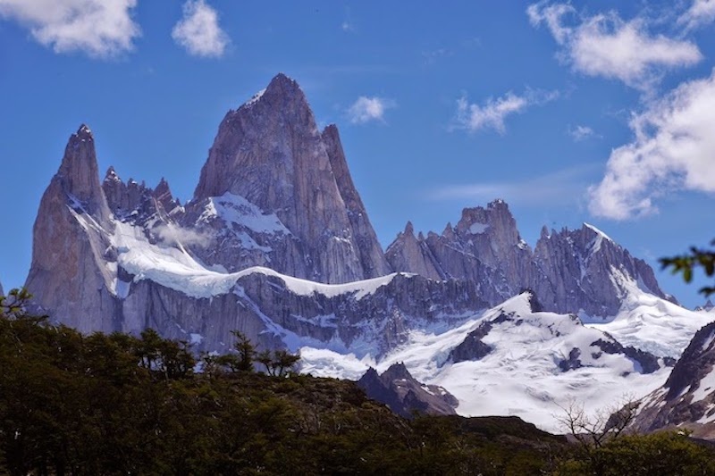 Tall, narrow, craggy mountains of Patagonia rise up to a blue sky