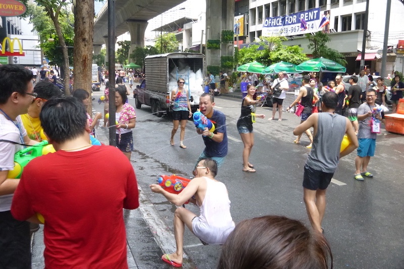 People on a city street spray each other with water pistols in the Songkran water festival, Bangkok.