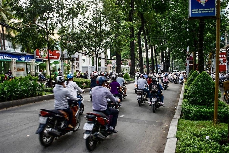 People riding scooters on busy street in Vietnam