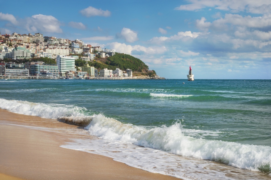 waves break on the sandy shore of Haeundae Beach in Busan, South Korea