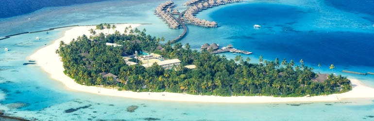 Aerial view of a tropical island and a line of overwater bungalows surrounded by an azure lagoon