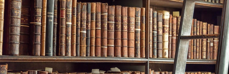 Old books arranged on a bookshelf