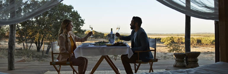 Couple having dinner and drinks with scenic background 