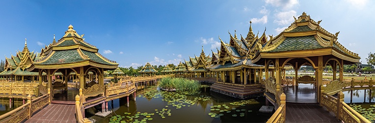 Temples over a murky pond with water lilies and blue skies 