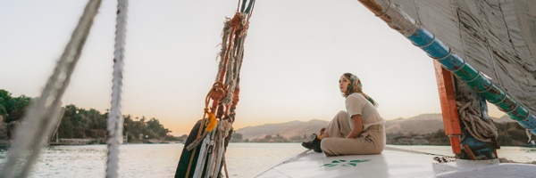 A person sitting on the bow of a sail boat