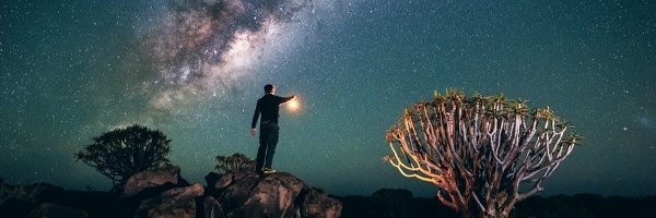 A person standing in a desert with a clear starry sky