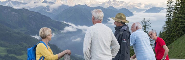 A group of elderly people looking out over mountains in Switzerland