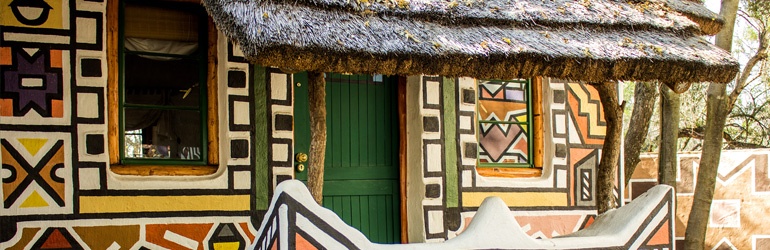 A close up of a traditional house with unique paintings on the outside