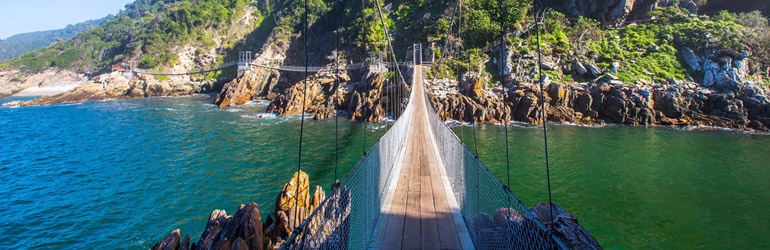 The view along a narrow swing-bridge over a rocky sea channel
